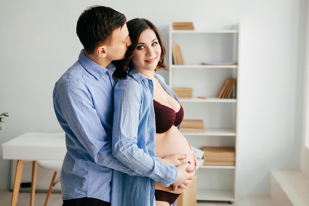 Pregnant beautiful girl posing with her husband