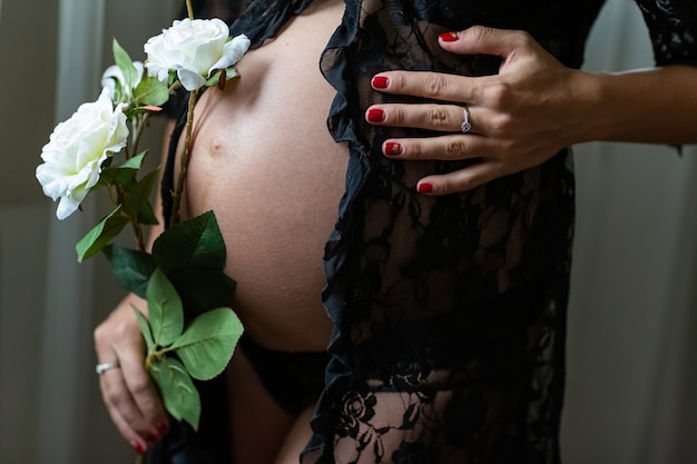 Pregnant belly closeup with beautiful flowers