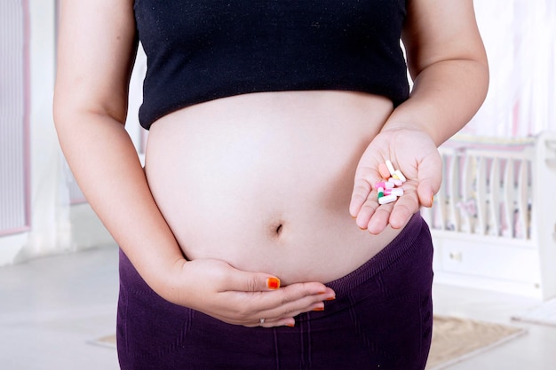 Pregnant belly and drugs on hand