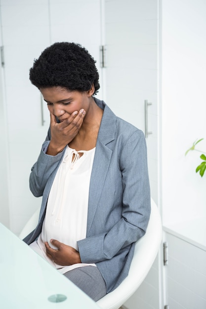 Pregnant businesswoman feeling sick in the office