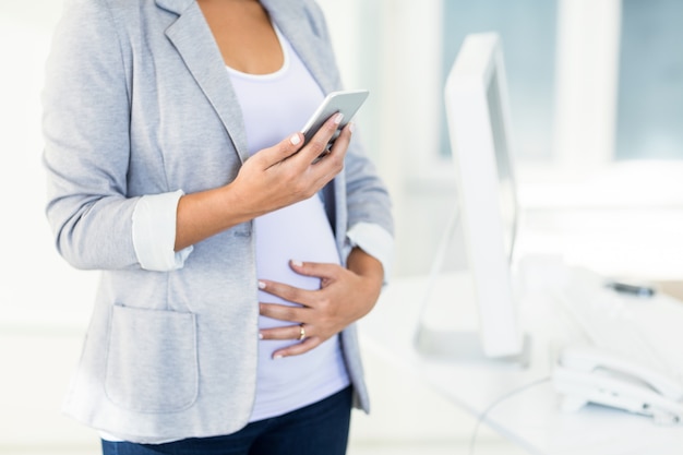 Pregnant businesswoman using phone