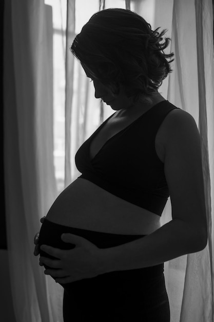 Pregnant caucasian woman dreaming about her baby. Studio shot