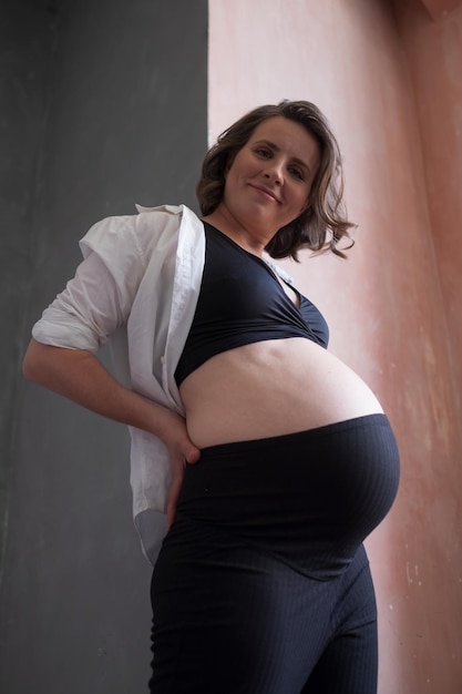 Photo pregnant caucasian woman posing in studio during photoshoot.