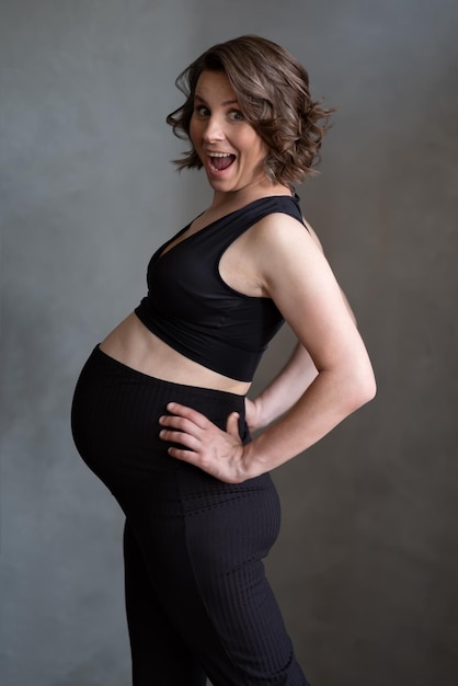 Pregnant caucasian woman posing in studio during photo studio shoot.