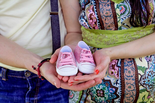 Coppie incinte che tengono i loro stivali del bambino futuri