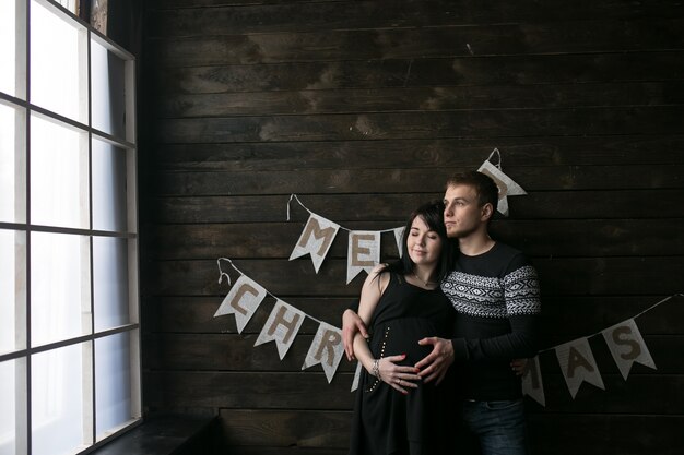 "Pregnant couple posing in studio"