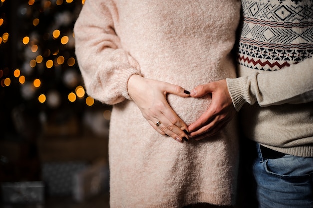 Pregnant couple putting hands on the belly