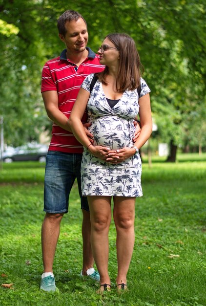 Photo pregnant couple touching womans belly standing in park