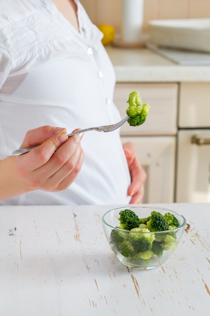 Pregnant female tasting broccoli