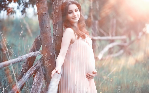 Pregnant girl in a dress in nature on a walk