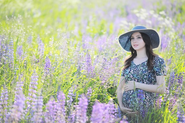 Pregnant girl in a field with lupines