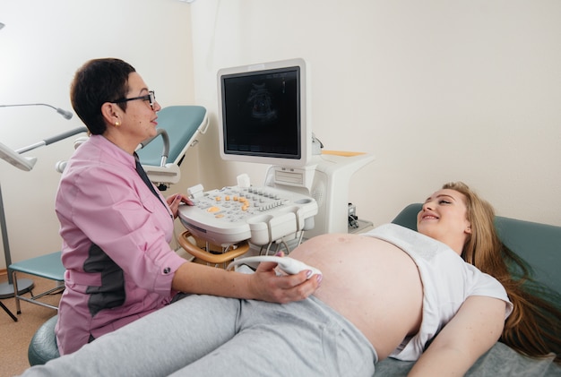 임신 한 소녀는 병원에서 복부 초음파 검사를받습니다. 건강 검사