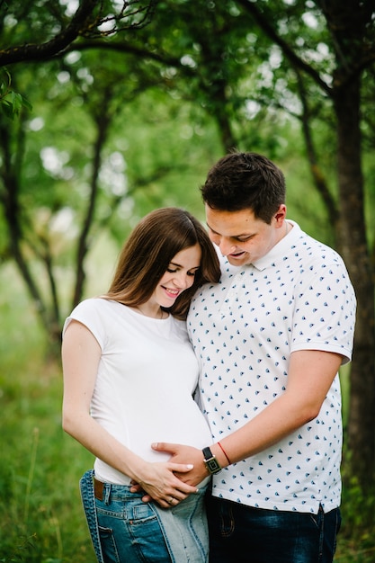 Pregnant girl and her husband are happy to hug.