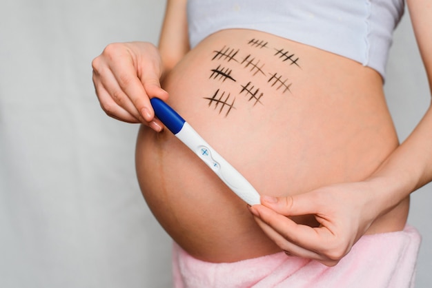肯定的な結果と妊娠検査を保持している妊娠中の女の子