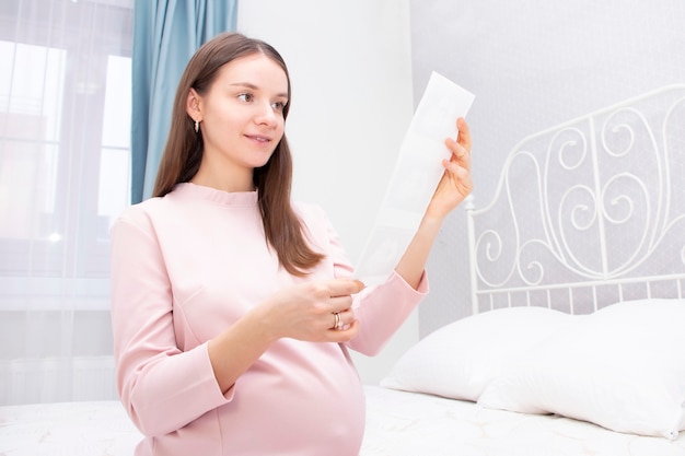 La ragazza incinta sta guardando un sonogramma