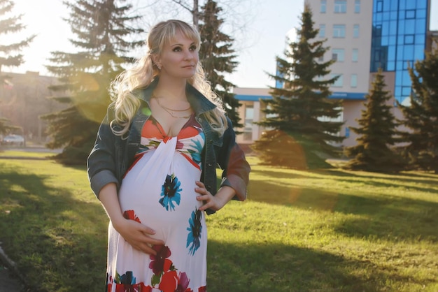 Pregnant girl is walking around the city park in early spring