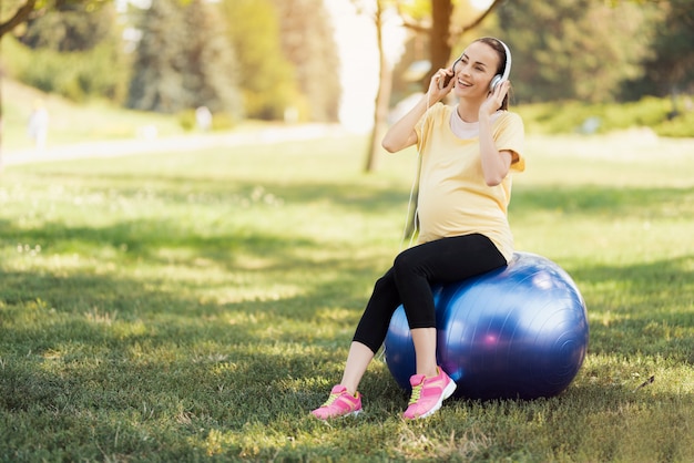 Pregnant Girl Smile And Listen Music in Park.