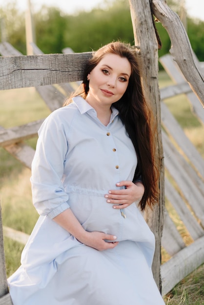 Photo pregnant girl in summer outdoors in the setting sun