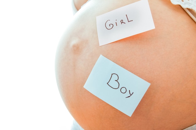 Pregnant girl on white wall with stickers