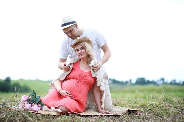 Pregnant girl with big belly and young man in park