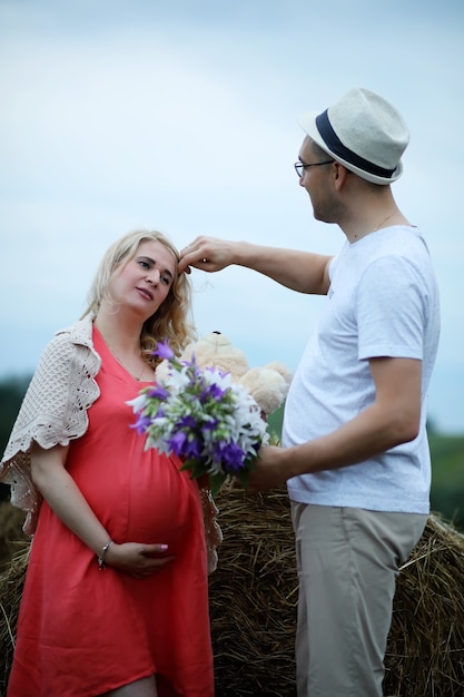 Pregnant girl with big belly and young man in park