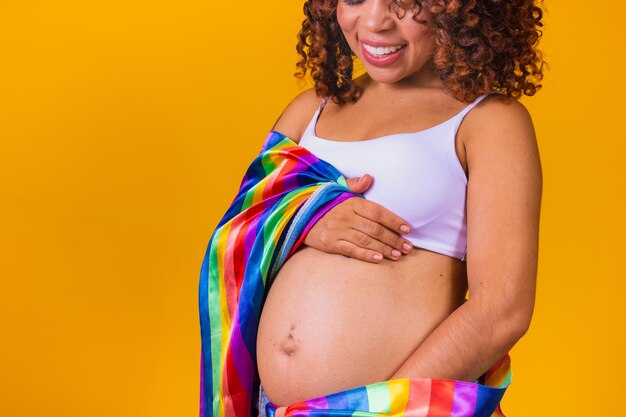 Pregnant lesbian woman on yellow background with space for text. pregnant afro lgbt woman