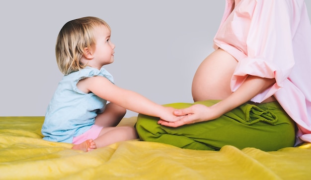 Photo pregnant mother and daughter together at home woman with her first child during second pregnancy