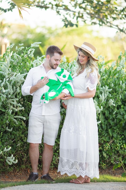 Pregnant mother and father holding baby clothes