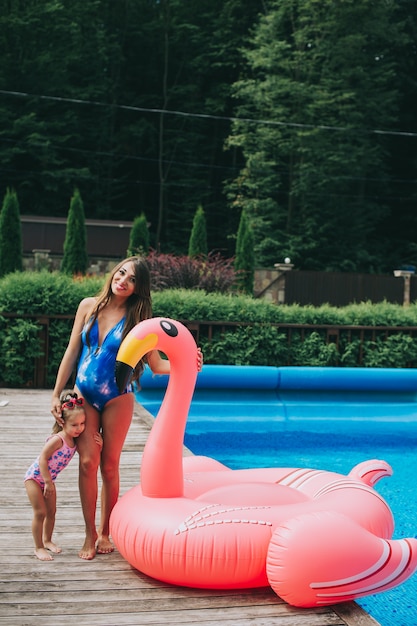 pregnant mother and her daughter was floating on an inflatable pink flamingos