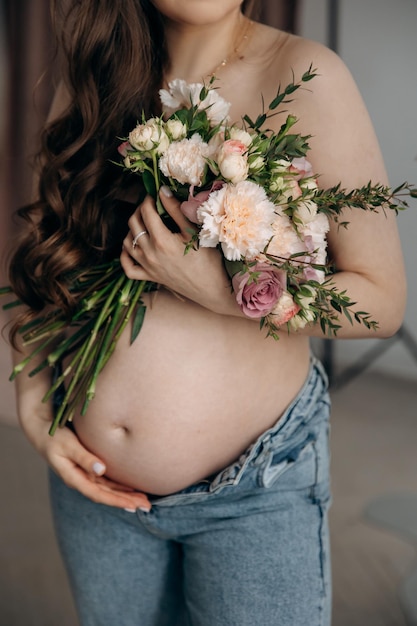 写真 新鮮な春の花束を持った妊娠中の母親