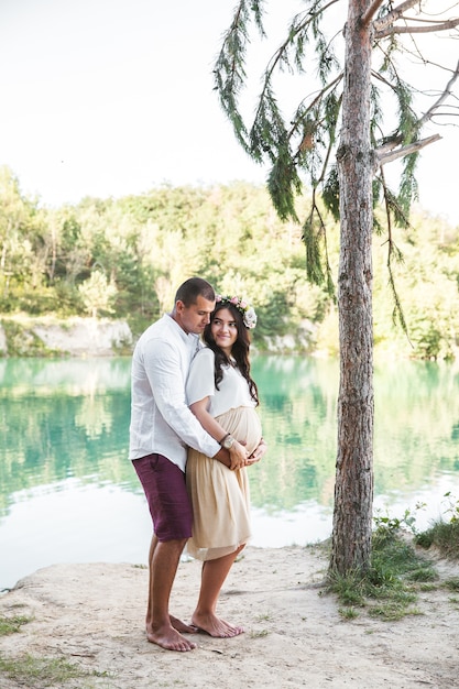 Pregnant with her husband on the beach