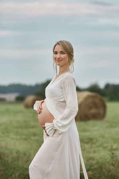 임신 9개월의 임산부는 아이가 태어나기 며칠 전 마을의 들판을 여름에 걷는다