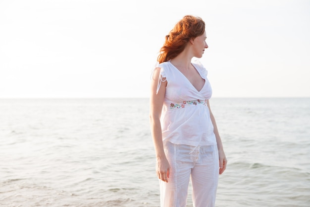 Donna incinta in spiaggia con luce bianca nel mediterraneo