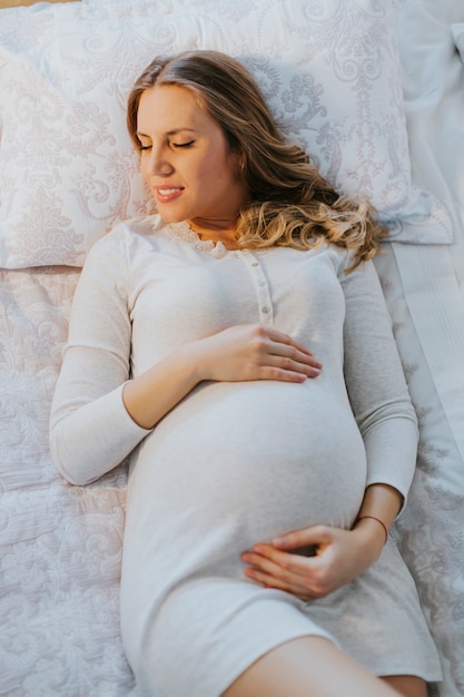 ベッドで妊娠している女性