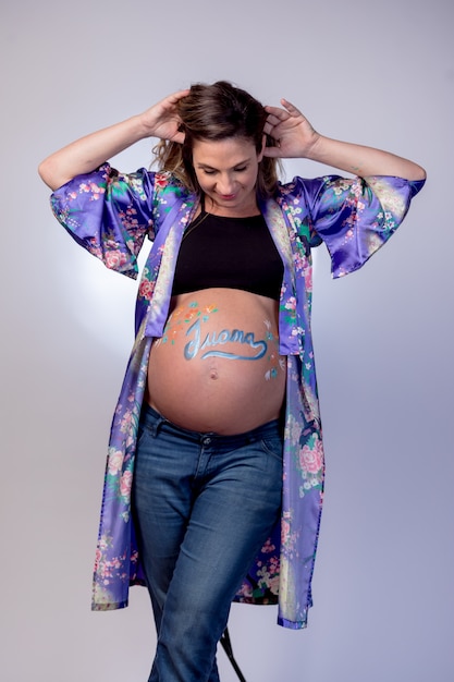 Pregnant woman caressing her tummy which has the name Juana written on it