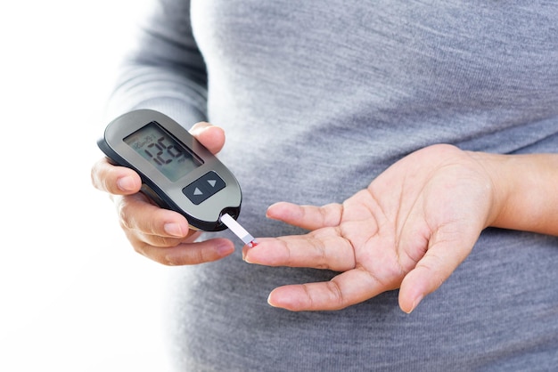 Pregnant woman checking blood sugar level with blood glucose meter Gestational diabetes