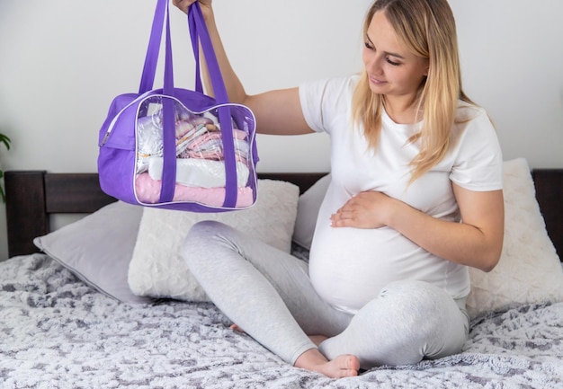 A pregnant woman collects baby things Selective focus Home