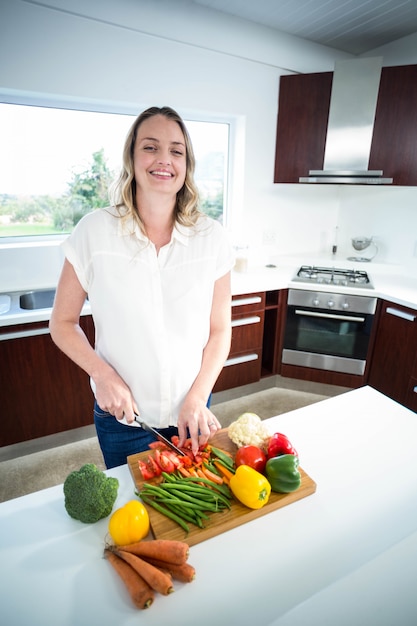 妊娠中の女性が台所で野菜を切る