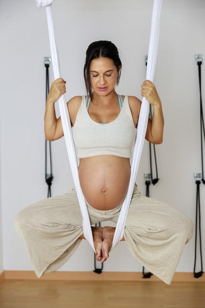 Pregnant woman doing aerial yoga