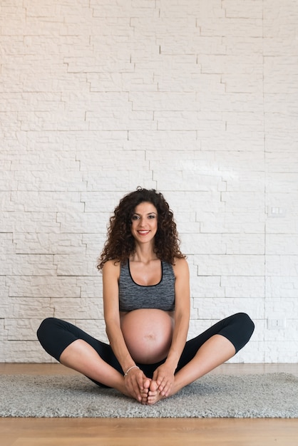 Pregnant woman doing stretching. Large copy-space on the top