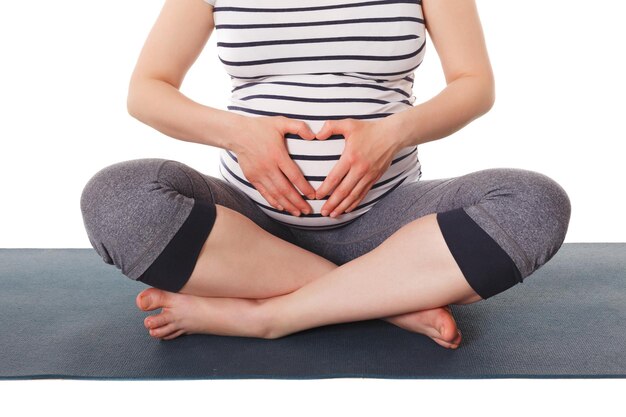 Foto donna incinta che fa yoga asana asana sukhasana