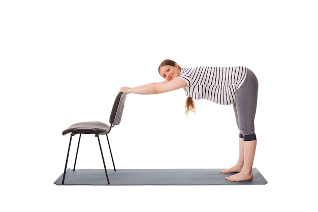 Pregnant woman doing yoga asana uttanasana