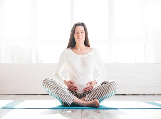 Pregnant woman doing yoga at home