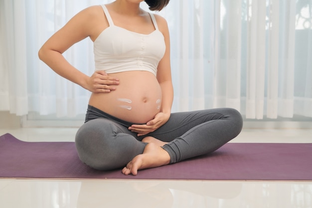 Pregnant woman doing yoga in living room