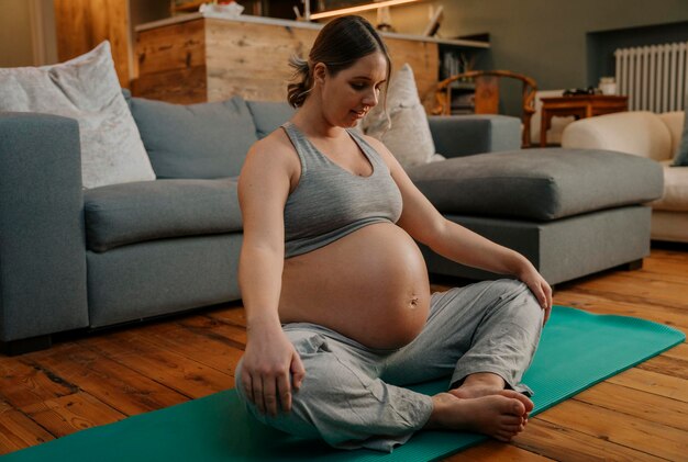 Pregnant woman doing yoga pose in living room