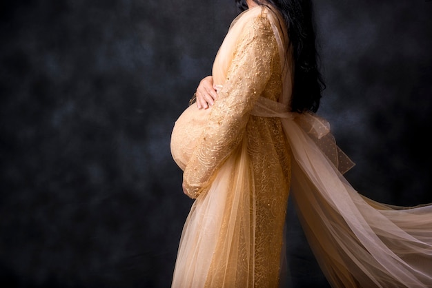 드레스에 임신 한 여자는 배꼽에 손을 보유