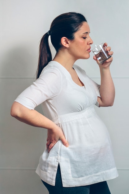 Фото Беременная женщина, пьющая стакан воды