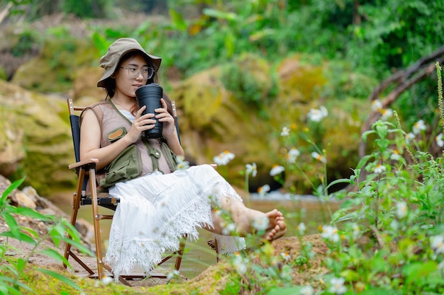 Pregnant woman drinking water by the waterfall