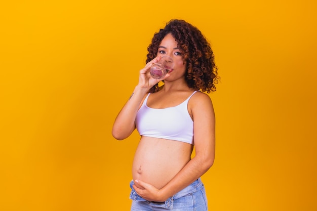 Pregnant woman drinking water. Pregnancy care. Pregnant woman hydrating herself by drinking water