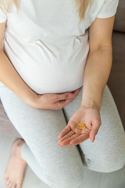 Pregnant woman drinks omega three Selective focus